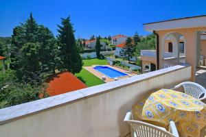 un balcone con tavolo, sedie e piscina di Sun Palace Residence a Premantura