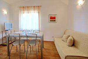 uma sala de estar com uma mesa e cadeiras e um sofá em Sun Palace Residence em Premantura
