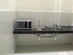 a bathroom with two sinks and a microwave on a counter at Kampar Private Roomstay W in Kampar