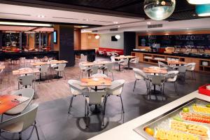 a restaurant with tables and chairs and a bar at Ibis Saigon Airport in Ho Chi Minh City