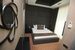 Pokój hotelowy z łóżkiem i lustrem w obiekcie Armada Villa Hotel w mieście Baku