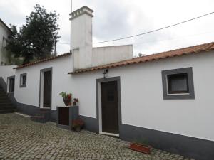 een wit huis met een deur en een geplaveide straat bij Apartamento 1 - Fundação de Veiros in Veiros