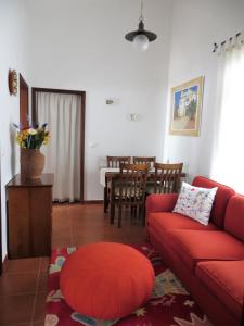 een woonkamer met een rode bank en een tafel bij Apartamento 1 - Fundação de Veiros in Veiros