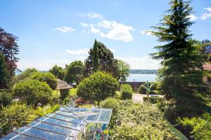 a glass garden with a view of the water at Apart Hotel Stadtgarten in Überlingen