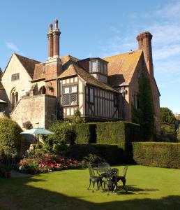 Amberley Castle- A Relais & Chateaux Hotel في أَمبيرلي: منزل كبير مع حديقة أمامه