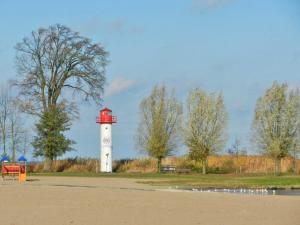 ウッカーミュンデにあるHausboot Ueckermuende Typ FLOATINGの鳥のいる公園の赤白灯台