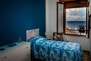 a bedroom with a bed and a window with the ocean at Piana delle Galee in Scilla