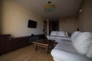 ein Wohnzimmer mit 2 weißen Sofas und einem Tisch in der Unterkunft Cozy apartment with a wonderful lake view in Telšiai