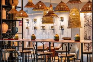 a bar with chairs and vases on a wall at Vincci Puertochico in Santander