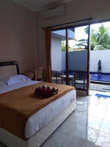 - une chambre avec un grand lit et une grande fenêtre dans l'établissement Star Bali Guest House, à Canggu