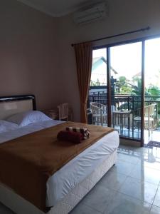 - une chambre avec un grand lit et un balcon dans l'établissement Star Bali Guest House, à Canggu