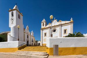 ein Gebäude mit einem Uhrturm und einer Treppe davor in der Unterkunft Apartamento 1 - Fundação de Veiros in Veiros