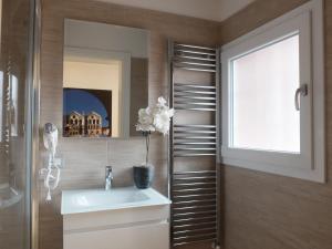 a bathroom with a sink and a mirror at Centro Storico Rooms in Ferrara +16 photos
