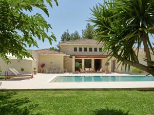 a backyard with a swimming pool and a house at Villa La Curva in Laganas