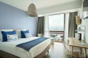 a bedroom with a large bed and a large window at Vincci Puertochico in Santander
