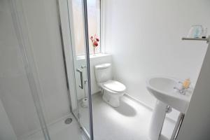 a white bathroom with a toilet and a sink at Bayswater House in Blackpool