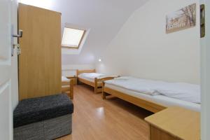 um pequeno quarto com 2 camas e uma cadeira em Zajazd Różany em Laski