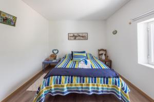 Un dormitorio con una cama con una manta de colores. en Casa do Olival, en Figueiró dos Vinhos