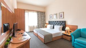 阳光海滩Lotus Family Hotel - Free Parking的配有床和书桌的酒店房间