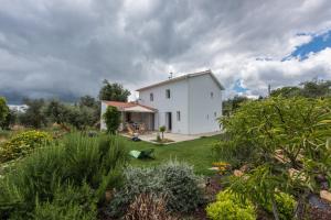 una casa blanca en medio de un jardín en Casa do Olival, en Figueiró dos Vinhos