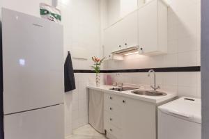 セビリアにあるPrecioso Apartamento Sevilla Centroの白いキッチン(シンク、冷蔵庫付)