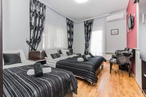 1 dormitorio con 2 camas y sofá en Villa Dudan LakeView, en Ohrid