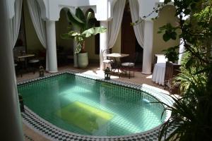 a swimming pool in the middle of a house at Riad Alida in Marrakech