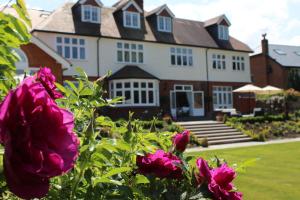 a large house with pink flowers in front of it at Ditton Lodge in Kingston upon Thames