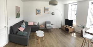 ein Wohnzimmer mit einem Sofa und einem TV in der Unterkunft Le Wim'Heureux in Wimereux