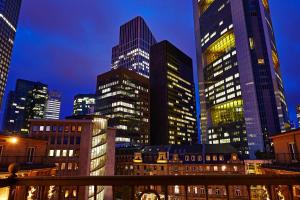 a group of tall buildings in a city at night at Steigenberger Icon Frankfurter Hof in Frankfurt