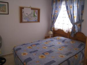 トレビエハにあるApartamento Pascualのベッドルーム1室(青いキルトのベッド1台、窓付)