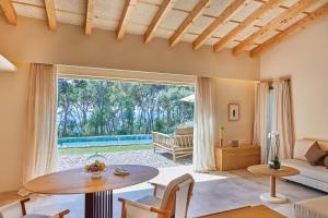 a living room with a table and a large window at Pleta de Mar, Grand Luxury Hotel by Nature - Adults Only in Canyamel