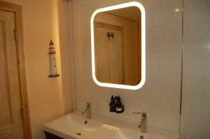 a bathroom with a white sink and a mirror at Waterfall Lodge - private waterfall and sauna in Killin +46 photos