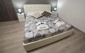 1 dormitorio con cama con colcha gris y blanca en Almayer La Locanda, en Gaeta