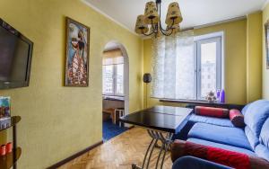 モスクワにあるАпартаменты на Большой Якиманке 32のリビングルーム(青いソファ、テーブル付)