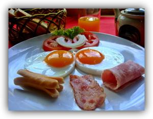 a plate with eggs and other food on a table at Hotel Alster in Jevíčko