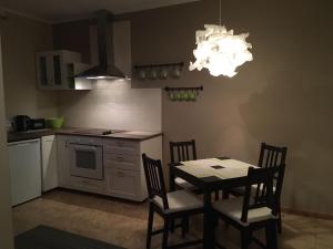 eine Küche mit Tisch und Stühlen und einem Kronleuchter in der Unterkunft Apartaments Selga in Roja
