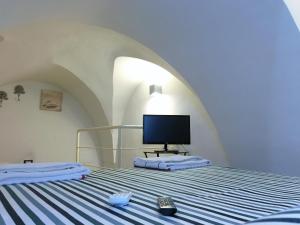 una camera con un letto e una TV di Cathedral Suite a Otranto