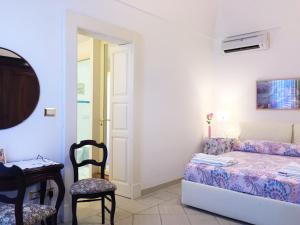 a bedroom with a bed and a table and a chair at Cathedral Suite in Otranto +24 photos