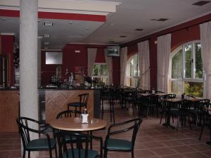 un restaurante con mesas y sillas y un bar en Hotel La Mora, en Villaseca de Laciana