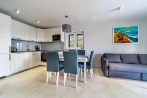 a kitchen and dining room with a table and a couch at Modern Villa Christian with pool, sauna, and jacuzzi, 10 min walk from the beach in Malinska