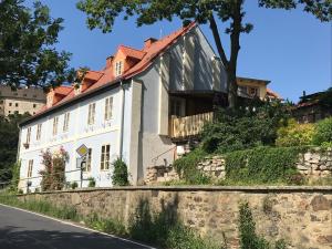 uma casa branca com um telhado vermelho numa rua em Penzion Modrý Svět em Loket