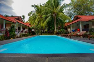 a large blue swimming pool in front of a house at Fullmoon House Samui in Lamai