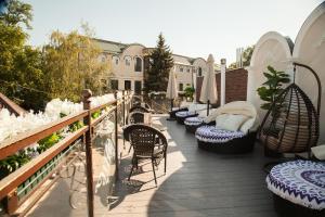 eine Terrasse mit Stühlen und Sonnenschirmen auf einem Balkon in der Unterkunft Bellagio Hotel in Rostow am Don