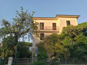un gran edificio amarillo con balcón. en Villa la Fonte, en Marina di Pietrasanta