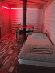 1 dormitorio con 1 cama, mesa y sillas en Abyrvalg Hotel, en Issad