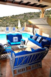 un patio con mobili blu accanto alla piscina di Villa Ocean Breeze a Peyia