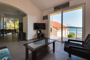 a living room with a glass table and a view of the ocean at Jadrija 6 in Šibenik