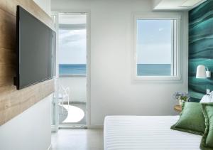 a bedroom with a bed with a flat screen tv at Hotel Meeting in Riccione