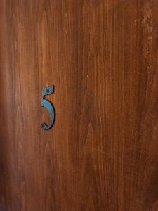a wooden door with the number six on it at Guest house Vukovic in Podgorica
